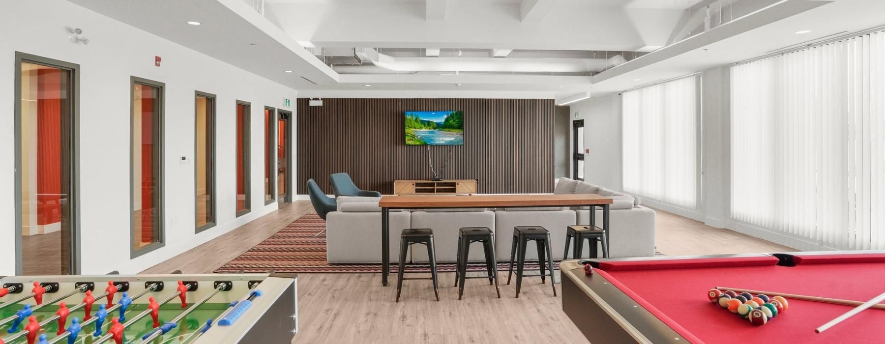 a room with a pool table and chairs